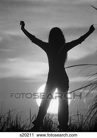 Silhouetted Figure Woman Standing Arms Stretched Up Raised Above Head On Grassy Hill Against Setting Sun 1970S 1980S View Large Photo Image Stock Image - Silhouetted Figure Woman Standing Arms Stretched Up Raised Above Head On Grassy Hill Against Setting Sun 1970S 1980S. Fotosearch