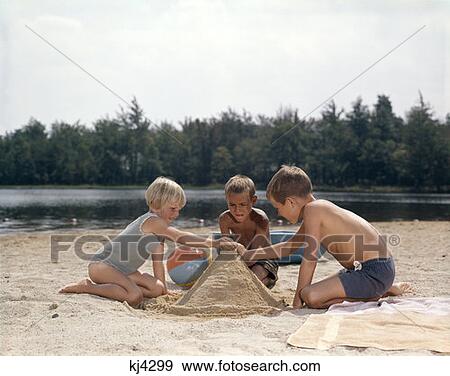 Three Children Playing In Sand At Beach Building Sand Castle Beach Ball Lake View Large Photo Image Stock Photo - Three Children Playing In Sand At Beach Building Sand Castle Beach Ball Lake. Fotosearch