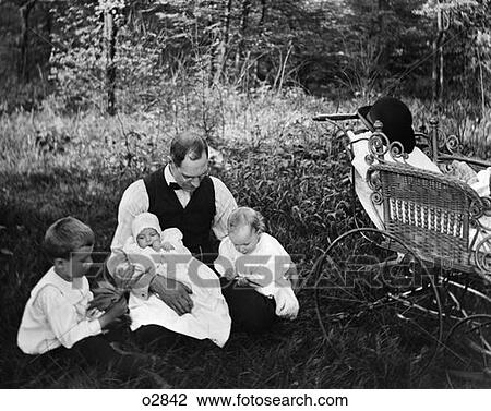 Stock Image - Turn Of The Century Father Sitting In Woods With Three Children Baby Carriage Off To Side . Fotosearch