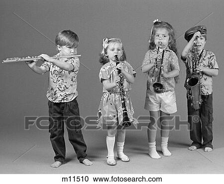 Stock Image - Two Boys And Two Girls Playing Flute Clarinet Trumpet And Saxophone Indoor . Fotosearch