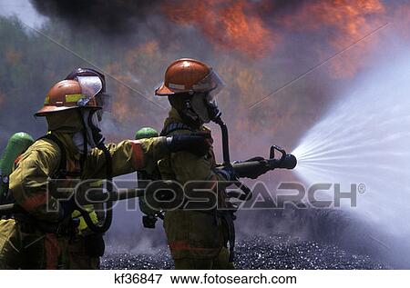 Two Firefighters Spraying Fire With Water From Hose View Large Photo Image Stock Photo - Two Firefighters Spraying Fire With Water From Hose . Fotosearch