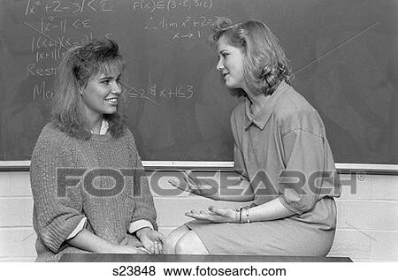Two Students In College Classroom Woman Talking To Each Other Blackboard In Background View Large Photo Image Stock Photo - Two Students In College Classroom Woman Talking To Each Other Blackboard In Background . Fotosearch