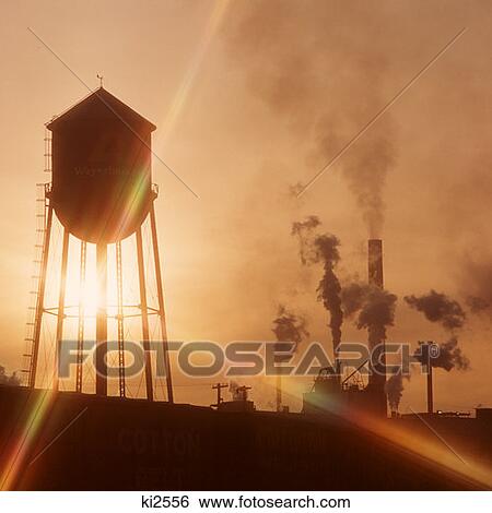 Stock Photograph - Weyerhauser County, Longview, Washington Water Tower Smokestacks Beams Of Sunlight At Sunset. Fotosearch