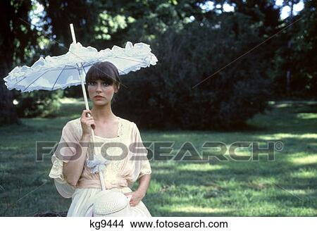 Woman Brown Hair Pink White Dress White Hat Pink Ribbon White Parasol Portrait 1970S 1979 View Large Photo Image Picture - Woman Brown Hair Pink White Dress White Hat Pink Ribbon White Parasol Portrait 1970S 1979. Fotosearch