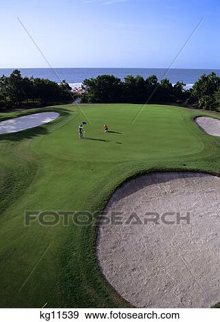 Stock Photo - Woman Playing Golf And Man Watching Her. Fotosearch