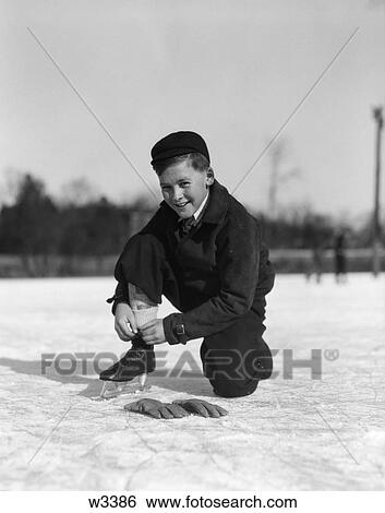 1920 1920S 1930 1930S Boy Tying Ice Skate Lace Kneeling On Ice Looking At Camera View Large Photo Image Stock Photograph - 1920 1920S 1930 1930S Boy Tying Ice Skate Lace Kneeling On Ice Looking At Camera . Fotosearch