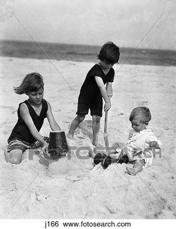 1920 1920S Children Kids 3 Playing Sand Beach Girl Bucket Pail Boy Digging Shovel Toddler View Large Photo Image Stock Photograph - 1920 1920S Children Kids 3 Playing Sand Beach Girl Bucket Pail Boy Digging Shovel Toddler . Fotosearch