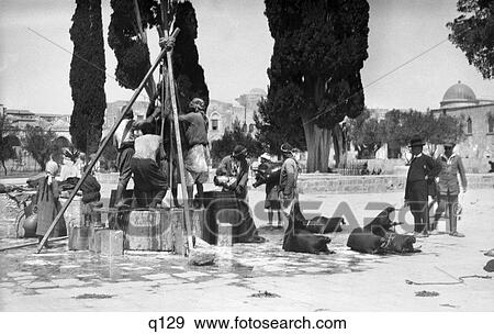 Stock Photo - 1920S 1930S 1920 1930 Locals Filling Goat Skins With Water At Well In Palestine Jerusalem . Fotosearch