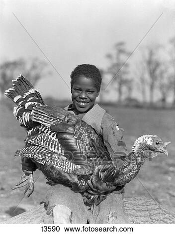 1920S 1930S African-American Young Boy Smiling Holding Large Turkey View Large Photo Image Stock Image - 1920S 1930S African-American Young Boy Smiling Holding Large Turkey . Fotosearch