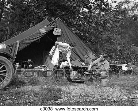 1920S 1930S Couple Man Woman On Fishing Camping Trip Vacation At Campsite Man Cooking Over Fire View Large Photo Image Stock Photo - 1920S 1930S Couple Man Woman On Fishing Camping Trip Vacation At Campsite Man Cooking Over Fire . Fotosearch