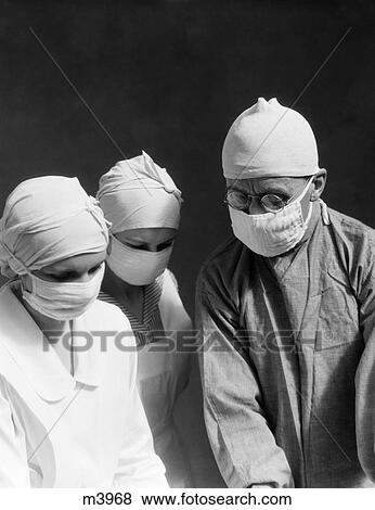 1920S 1930S Doctor Two Nurses Wearing Surgical Masks Caps Looking Down View Large Photo Image Stock Photo - 1920S 1930S Doctor Two Nurses Wearing Surgical Masks Caps Looking Down. Fotosearch