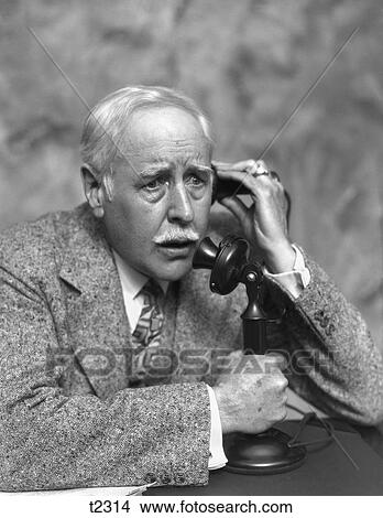 1920S 1930S Elderly Concerned Worried Man Talking On Candlestick Phone Business Man Tweed Suit Serious Expression View Large Photo Image Picture - 1920S 1930S Elderly Concerned Worried Man Talking On Candlestick Phone Business Man Tweed Suit Serious Expression. Fotosearch