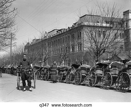 Stock Photo - 1920S 1930S Long Line Of Rickshaws Riksha Waiting At Grand Hotel Peking Beijing Trave Tansportation Taxi Pedicab. Fotosearch