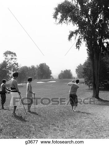 Stock Photo - 1920S 1930S Male Golfer Driving Down Fairway Two Women And Caddy Look On At The Berkshire Hotel & Country Club Ma . Fotosearch