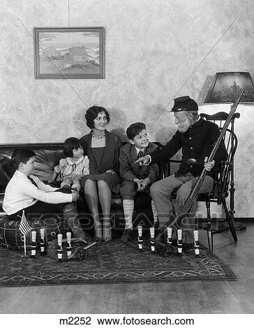 1920S 1930S Mother & Three Children Listening To Grandfather In Civil War Uniform Holding Rifle Tell War Stories View Large Photo Image Stock Image - 1920S 1930S Mother & Three Children Listening To Grandfather In Civil War Uniform Holding Rifle Tell War Stories . Fotosearch