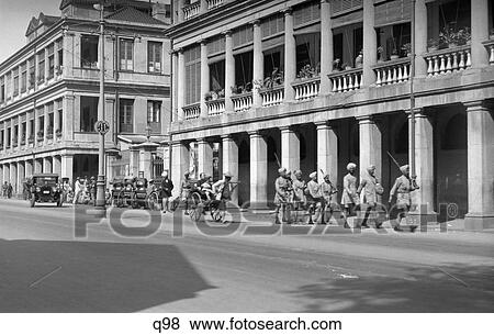 1920S 1930S Street Scene China Hong Kong Rickshaw Group Of Indian Gurkhas With Rifles Marching View Large Photo Image Stock Photo - 1920S 1930S Street Scene China Hong Kong Rickshaw Group Of Indian Gurkhas With Rifles Marching . Fotosearch