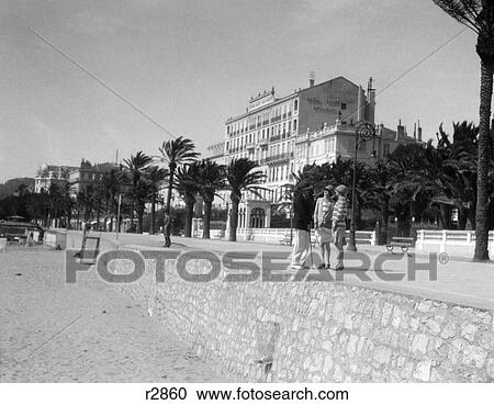 1920S 2 Women 1 Man Stand Talking On Promenade Cannes French Riviera Fashion Mediterranean Retro Vintage View Large Photo Image Stock Image - 1920S 2 Women 1 Man Stand Talking On Promenade Cannes French Riviera Fashion Mediterranean Retro Vintage . Fotosearch