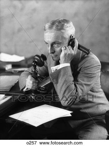 1920S Businessman At Desk Talking On Candlestick Phone View Large Photo Image Stock Photo - 1920S Businessman At Desk Talking On Candlestick Phone . Fotosearch