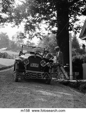 1920S Couple Man Woman Enter Motor Car Carrying Bags Fashion Trip Leisure Getaway Golf Bags Upscale Convertible View Large Photo Image Stock Photo - 1920S Couple Man Woman Enter Motor Car Carrying Bags Fashion Trip Leisure Getaway Golf Bags Upscale Convertible . Fotosearch