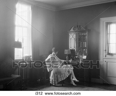 1920S Elegantly Dressed Woman Sitting At Desk Reading A Letter By Moody Window Light View Large Photo Image Stock Image - 1920S Elegantly Dressed Woman Sitting At Desk Reading A Letter By Moody Window Light. Fotosearch