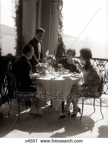 1920S Group Eating On Balcony With Waiter Serving Wine View Large Photo Image Stock Image - 1920S Group Eating On Balcony With Waiter Serving Wine . Fotosearch