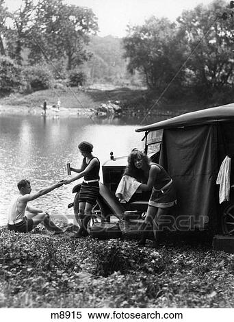 1920S Group Of Two Women And One Man At Lake With Touring Car Toweling Off Hair After Swimming View Large Photo Image Stock Photography - 1920S Group Of Two Women And One Man At Lake With Touring Car Toweling Off Hair After Swimming. Fotosearch
