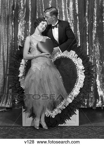 1920S Man Kissing Woman Holding Satin Heart View Large Photo Image Stock Photo - 1920S Man Kissing Woman Holding Satin Heart . Fotosearch