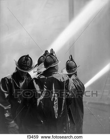 1920S Rear View Of Four Firemen In Black Slickers Squirting Two Hoses View Large Photo Image Stock Photo - 1920S Rear View Of Four Firemen In Black Slickers Squirting Two Hoses . Fotosearch