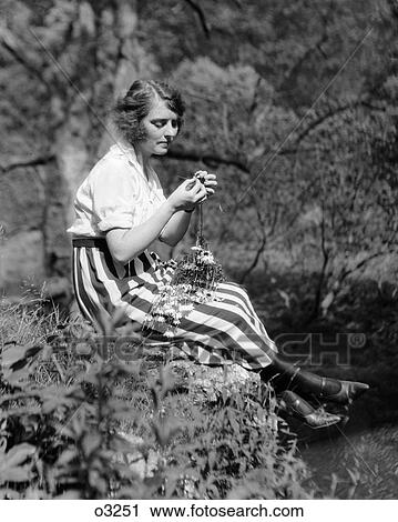 1920S Woman Sitting On Rock In Woods Playing With Flowers View Large Photo Image Stock Image - 1920S Woman Sitting On Rock In Woods Playing With Flowers . Fotosearch