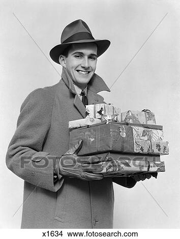 1930 1930S 1940 1940S Man In Coat Hat And Gloves Holding Pile Of Wrapped Presents Smiling At Camera View Large Photo Image Picture - 1930 1930S 1940 1940S Man In Coat Hat And Gloves Holding Pile Of Wrapped Presents Smiling At Camera . Fotosearch