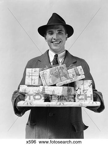 1930 1930S 1940 1940S Man In Hat And Coat Holding Wrapped Presents View Large Photo Image Stock Photograph - 1930 1930S 1940 1940S Man In Hat And Coat Holding Wrapped Presents . Fotosearch