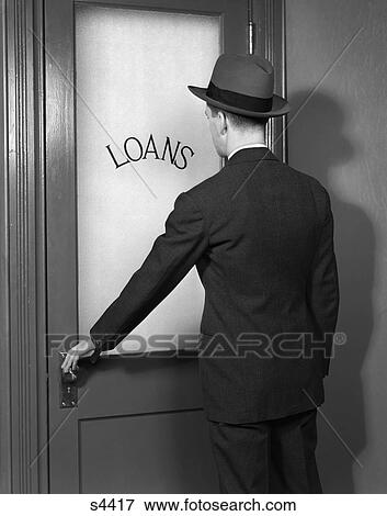 1930 1930S 1940 1940S Man In Suit And Hat Opening Door Marked Loans View Large Photo Image Stock Photo - 1930 1930S 1940 1940S Man In Suit And Hat Opening Door Marked Loans . Fotosearch