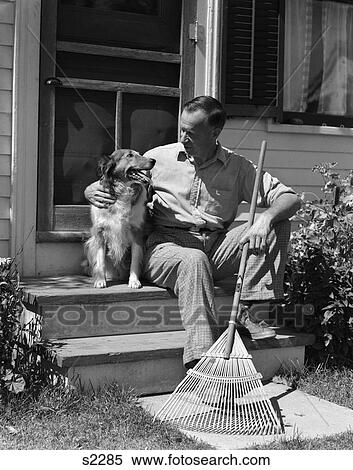 1930 1930S 1940 1940S Man Sitting On Stairs Holding Rake Petting Dog View Large Photo Image Stock Photography - 1930 1930S 1940 1940S Man Sitting On Stairs Holding Rake Petting Dog . Fotosearch