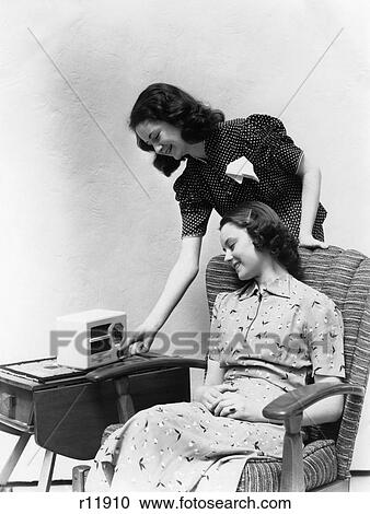 Stock Image - 1930 1930S 1940 1940S Two Women Smiling Listening To Radio. Fotosearch