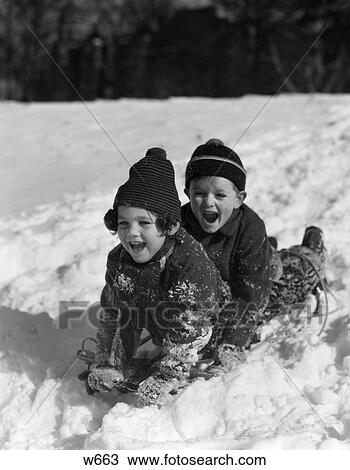 Stock Image - 1930 1930S Boy And Girl Laughing Sledding In Snow . Fotosearch