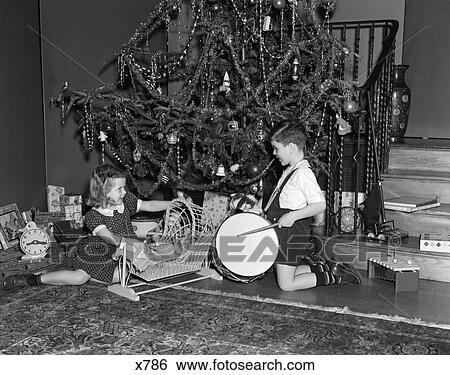 1930 1930S Boy And Girl Playing With Presents By Christmas Tree View Large Photo Image Stock Photograph - 1930 1930S Boy And Girl Playing With Presents By Christmas Tree . Fotosearch