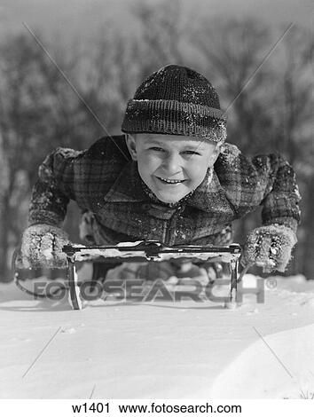 Stock Image - 1930 1930S Boy Playing On Sled In Snow Smiling Facing Camera . Fotosearch