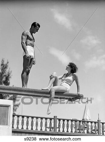 Stock Photo - 1930 1930S Couple By Swimming Pool On Diving Board Talking . Fotosearch