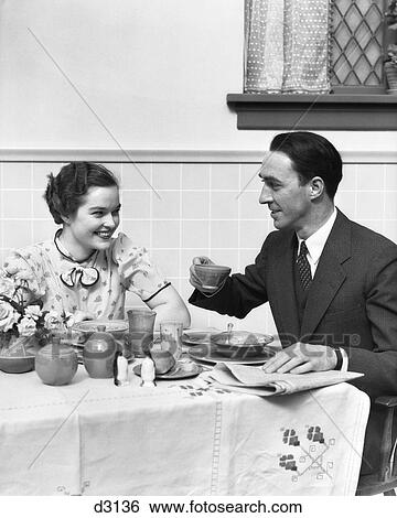 Stock Photograph - 1930 1930S Couple Eating Breakfast Drinking Coffee And Reading Newspaper . Fotosearch