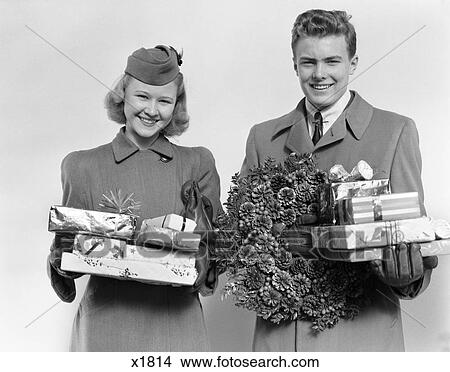 1930 1930S Couple In Winter Coats Holding Packages And Wreath Made Of Pine Cones 1940 1940S View Large Photo Image Picture - 1930 1930S Couple In Winter Coats Holding Packages And Wreath Made Of Pine Cones 1940 1940S . Fotosearch