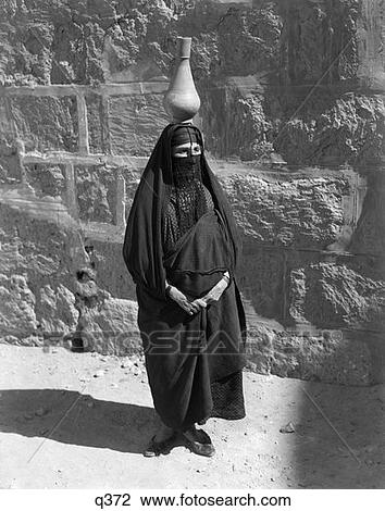 1930 1930S Egyptian Woman With Pitcher Balanced On Head Wearing Traditional Arab Muslim Garb Face Veiled Veil Rrr Retro View Large Photo Image Stock Image - 1930 1930S Egyptian Woman With Pitcher Balanced On Head Wearing Traditional Arab Muslim Garb Face Veiled Veil Rrr Retro. Fotosearch