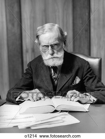 1930 1930S Elder Man In Glasses Sitting At Desk With Book View Large Photo Image Picture - 1930 1930S Elder Man In Glasses Sitting At Desk With Book. Fotosearch