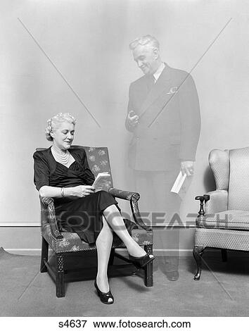 1930 1930S Elderly Woman Sitting In Chair Ghostly Figure Of Man Standing Looking At Her View Large Photo Image Stock Photo - 1930 1930S Elderly Woman Sitting In Chair Ghostly Figure Of Man Standing Looking At Her . Fotosearch