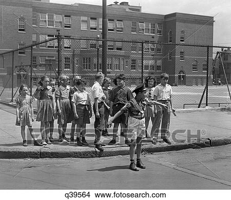 1930 1930S Group Wating At Curb School Crossing Guard Holding Them Back Student Students Children Boys Girls Paterson Nj View Large Photo Image Picture - 1930 1930S Group Wating At Curb School Crossing Guard Holding Them Back Student Students Children Boys Girls Paterson Nj. Fotosearch