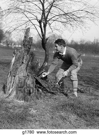 1930 1930S Man Golfer Taking Picing Golf Ball Out Of Burned Out Tree Stump Trunk Rules Fair Play Golfing View Large Photo Image Stock Image - 1930 1930S Man Golfer Taking Picing Golf Ball Out Of Burned Out Tree Stump Trunk Rules Fair Play Golfing. Fotosearch