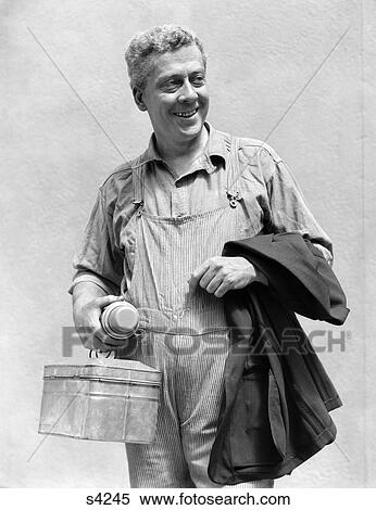 1930 1930S Man In Overalls Work Uniform Holding Thermos Lunchboc And Jacket View Large Photo Image Stock Photography - 1930 1930S Man In Overalls Work Uniform Holding Thermos Lunchboc And Jacket . Fotosearch