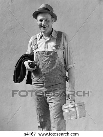 Stock Photo - 1930 1930S Man In Work Uniform Overalls Holding Lunchbox And Thermos . Fotosearch
