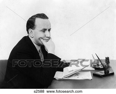 1930 1930S Man Sitting At Desk Holding Papers With Concerned Look On Face View Large Photo Image Stock Photo - 1930 1930S Man Sitting At Desk Holding Papers With Concerned Look On Face . Fotosearch