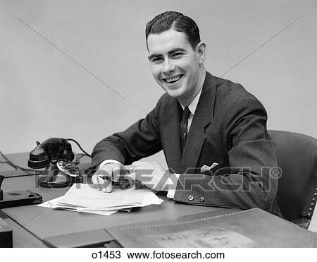 1930 1930S Man Sitting At Desk In Office Holding Pen Smiling View Large Photo Image Stock Image - 1930 1930S Man Sitting At Desk In Office Holding Pen Smiling . Fotosearch
