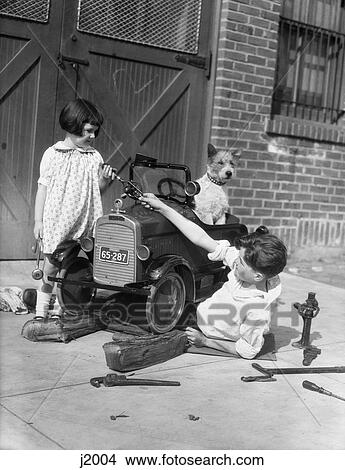 1930 1930S Retro Two Children Fixing Automobile Dog View Large Photo Image Picture - 1930 1930S Retro Two Children Fixing Automobile Dog . Fotosearch